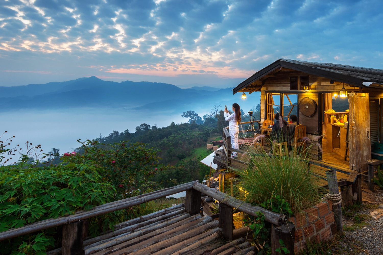 Woman taking a photo to morning mist at Phu Lang Ka, Phayao in Thailand.